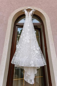 Hanging white wedding dress on the balcony.