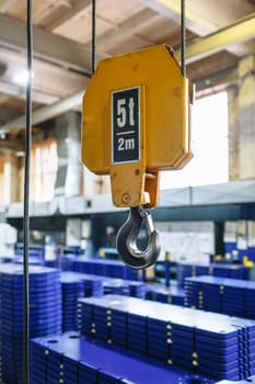 A large warehouse of metal plates lying on pallets. Crane