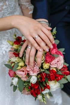 The hands of the newlyweds, who are holding on to the little fingers