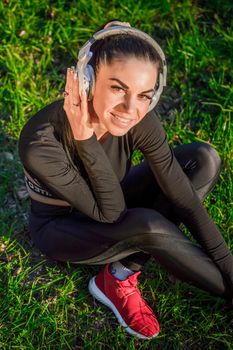 Pretty young woman listening to music with headphones./Nice sporty girl with headphones listening to music.