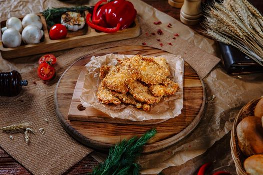 Breaded chicken fillet on the kitchen table. Top view.