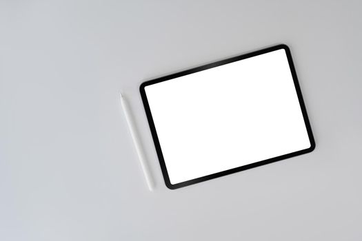 Digital tablet with blank screen and stylus pen on white background. Top view, flat lay, copy space.