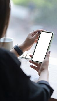 Young woman using smartphone at bright office. Blank screen for graphics display montage.