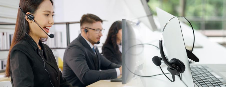 Business people wearing headset working in office to support remote customer or colleague. Call center, telemarketing, customer support agent provide service in broaden view .