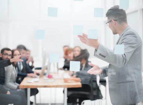 head of the project, pointing to the sticky notes during a work meeting. business concept