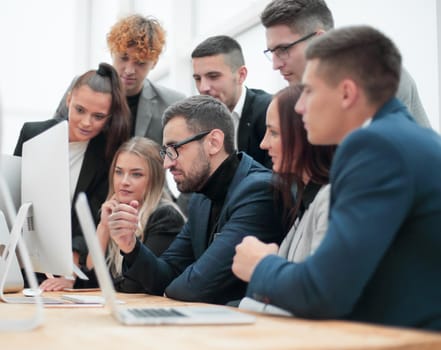 team of young employees looking together at a computer screen. success concept