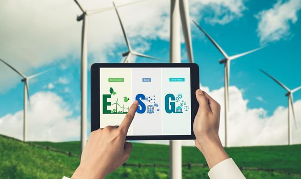 Green business transformation for environment saving and ESG business concept. Businessman using tablet to set corporate goal toward environmental friendly management and alternative clean energy use.