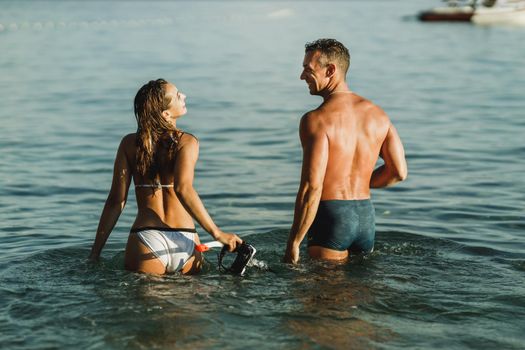 Cheerful young couple having fun in the sea water and enjoys on vacation.