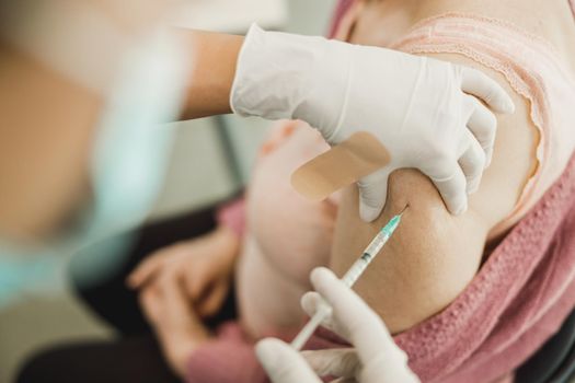 Close-up of a senior woman receiving a vaccine due to coronavirus pandemic.