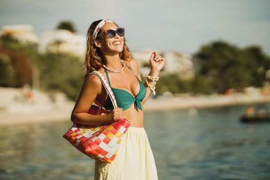 An attractive young woman in bikini is having fun on the beach and enjoying a summer vacation.