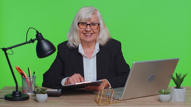 Successful employment hire approved. Senior ceo businesswoman director sitting at workplace, looking at camera, having interview job discussion video conference call online. Working at green office