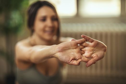 Young woman is doing yoga meditation in the living room at home. 