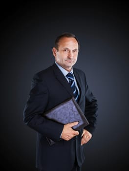 Confident businessman isolated on a dark background.