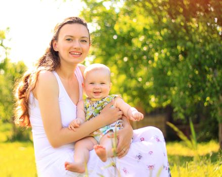 Beautiful Mother And Baby outdoors. Nature. Beauty Mum and her Child playing in Park together