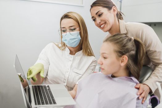 Shot of a teenager girl and her mom having a consultation with her dentist.
