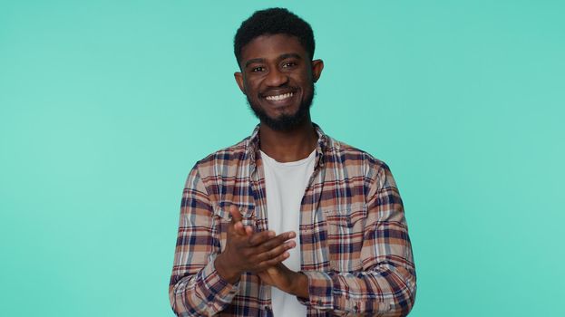 Great job, nice. Cheerful positive african american man in shirt showing thumbs up and nodding in approval, successful good work. Young one guy on blue studio background. People sincere emotions