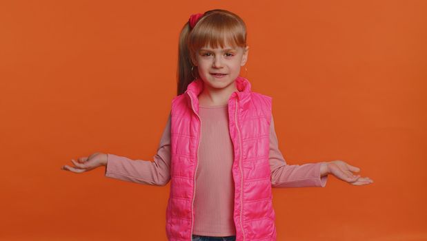 What Why. Sincere irritated little girl raising hands in indignant expression asking reason of failure demonstrating disbelief irritation by troubles. Confused child isolated on orange wall background