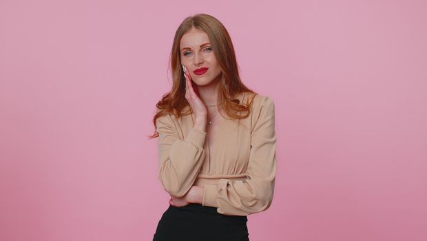 Dental problems. Businesswoman girl touching cheek, closing eyes with expression of terrible suffer from terrible toothache, sensitive teeth, cavities. Young woman isolated on pink studio background