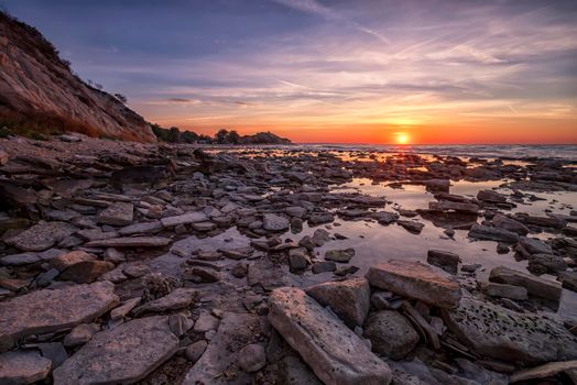 Amazing sunrise over the rocky coast sea.