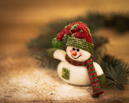 Christmas background with Christmas tree and snowman on a rustic wooden board
