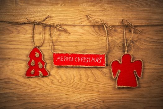 the inscription with Christmas on wooden background with Christmas tree and angel