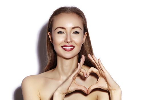 Romantic young Woman making Heart Shape with her Fingers. Love and Valentines Day Symbol. Fashion girl with Happy Smile on white background.