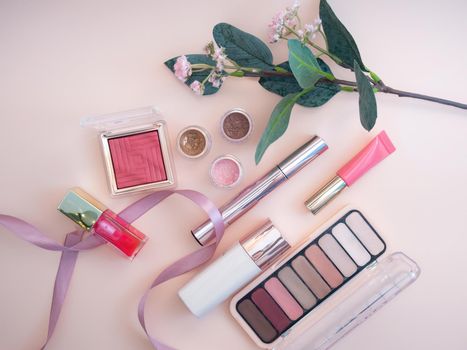 set of beauty cosmetics for female face and eye makeup on pink background . photo