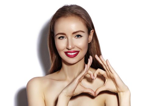 Romantic young Woman making Heart Shape with her Fingers. Love and Valentines Day Symbol. Fashion girl with Happy Smile on white background.