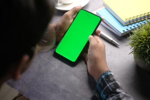 top view of man hand using smart phone on office desk.