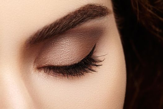 Close-up macro of beautiful female eye with perfect shape eyebrows. Clean skin, fashion naturel make-up. Good vision.
