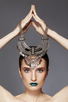 Beautiful Woman with Silver Necklace in hand over head. Modern Indian Fashion Style. Jewelry Luxury Accessories. Bright Makeup