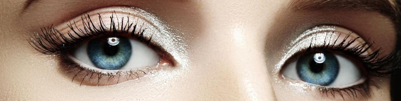 Closeup female eyes with bright make-up, great shapes brows, extreme long eyelashes. Celebrate makeup, luxury eyeshadows. Macro of beautiful eye. Good vision