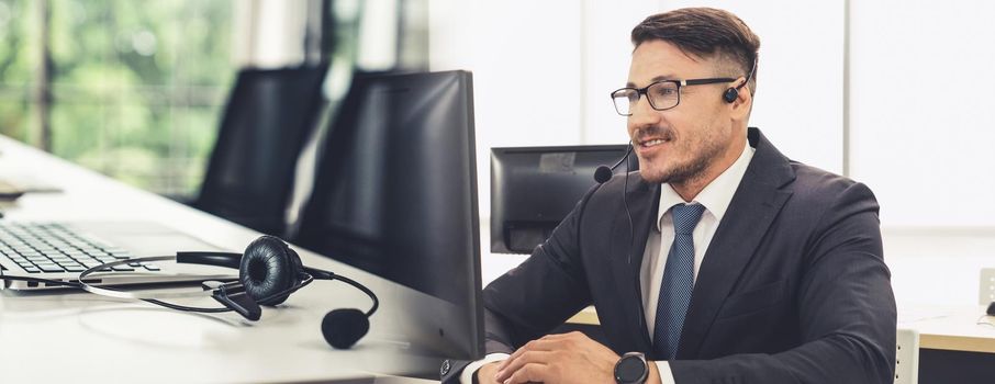 Business people wearing headset working in office to support remote customer or colleague. Call center, telemarketing, customer support agent provide service in broaden view .