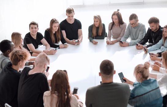 study group of young people sitting at a round table . photo with copy space