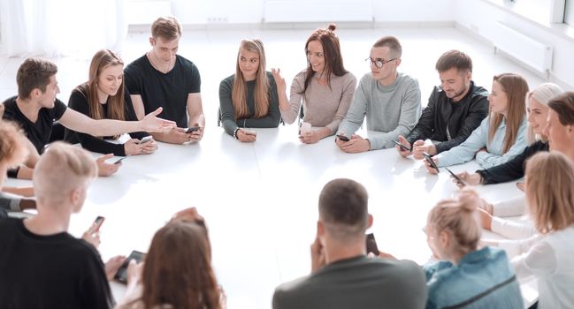 study group of young people sitting at a round table . photo with copy space