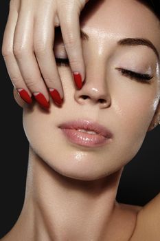 Luxury woman style vamp. Cosmetics, manicure on nails with bright red polish. Dark red lips make-up and nail color. Beauty close-up portrait of female model with red lipstick and clean skin