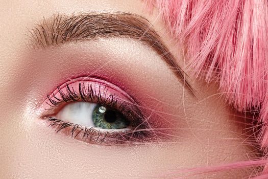 Closeup Macro of Pink Fashion Eye Make-up. Expressive Makeup, Bright Summer Eyeshadows and Magenta Color Hair, Shiny Skin