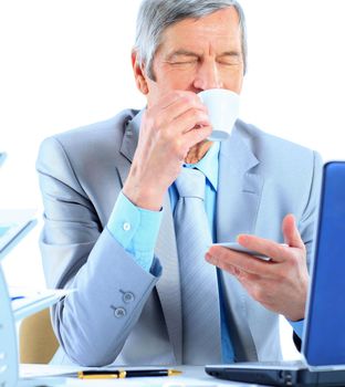The businessman at the age of drinking coffee during the break. Isolated on a white background.