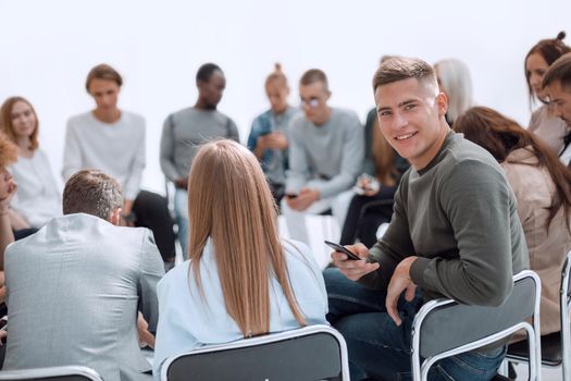 close up. handsome guy sitting in a circle casual young people