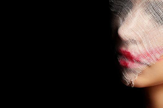 Girl in Glamorous Joker Mask for Halloween. Woman Face Wrapped in Bandage with Art Make-up. Creative Masquerade Style. Plastic Surgery