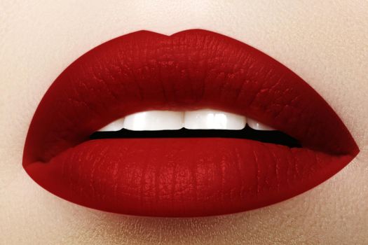 Cosmetics, makeup and trends. Bright lip gloss and lipstick on lips. Closeup of beautiful female mouth with red lip makeup. Beautiful part of female face. Perfect clean skin