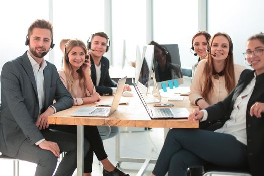 group of employees with a headset sitting at a Desk. photo with copy-space