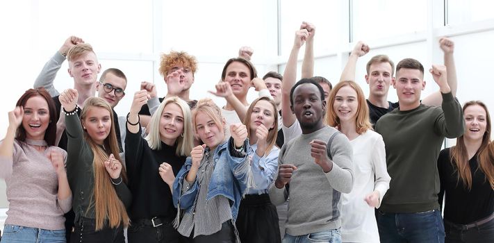 large group of happy young people showing their success. isolated on white background