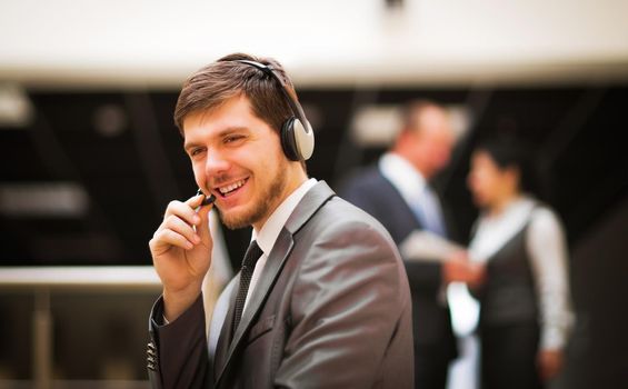 Young customer service operator talking on headset, smiling.