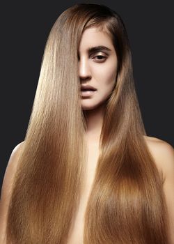 Beautiful yong woman with long straight brown hair. Sexy fashion model with smooth gloss hairstyle, keratin treatment.