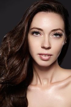 Beautiful young woman model with flying brown color hair. Beauty portrait with clean skin, glow glamour fashion makeup. Make up, curly hairstyle. Haircare, make-up. Horizontal beauty portrait