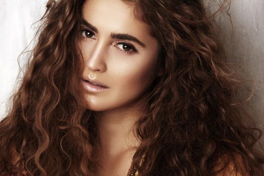 Beautiful young woman with long curly hairstyle, fashion jewelry with long brunette hair. Sexy girl in vogue style. Pretty arabian beauty portrait of female face. Indian style clothes, long dress