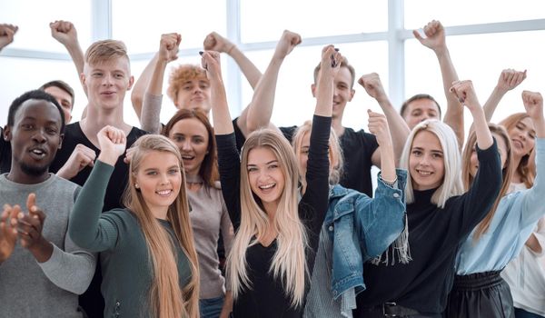 close up. group of smiling young people showing their success. isolated on white