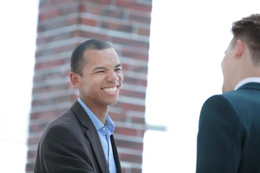 smiling young businessman on background of office.photo with copy space