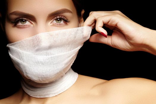 Beautiful woman with a bandage mask on face. Fashion eye make-up. Beauty plastic surgery or protection hygiene in viral covid-19 pandemic